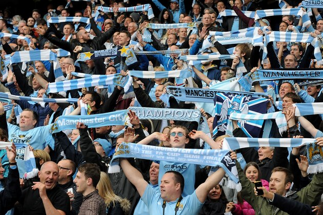 Supporters celebrate after Manchester City is crowned Premier League  Champions during the English Premier League soccer match between Manchester City and West Ham United at the Etihad Stadium,  Manchester, England, Sunday, May 11, 2014. (AP Photo/Rui Vieira)