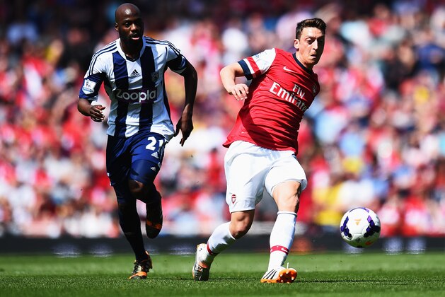 LONDON, ENGLAND - MAY 04:  Mesut Ozil (R) of Arsenal controls the ball ahead of Youssuf Mulumbu (L) of West Bromwich Albion during the Barclays Premier League match between Arsenal and West Bromwich Albion at the Emirates Stadium on May 4, 2014 in London, England.  (Photo by Shaun Botterill/Getty Images)