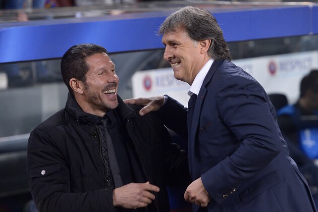 Atletico's coach Diego Simeone, left and Barcelona's coach Gerardo Martino greet each other before the start of a first leg quarterfinal Champions League soccer match between Barcelona and Atletico Madrid at the Camp Nou stadium in Barcelona, Spain, Tuesday April 1, 2014. (AP Photo/Manu Fernandez)