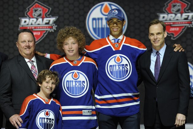 Darnell Nurse, second from right, a defenseman, stands with officials from the Edmonton Oilers sweater after being chosen  seventh overall in the first round of the NHL hockey draft, Sunday, June 30, 2013, in Newark, N.J. (AP Photo/Bill Kostroun)