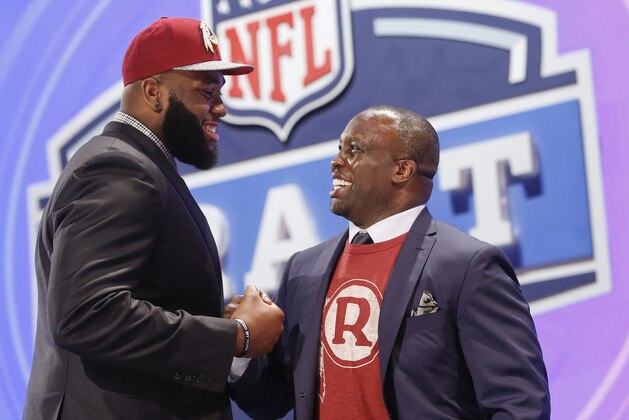 Virginia tackle Morgan Moses greets former Washington Redskins' linebacker London Fletcher after being selected by the Redskins as the 66th pick during the third  round of the 2014 NFL Draft, Friday, May 9, 2014, in New York. (AP Photo/Jason DeCrow)