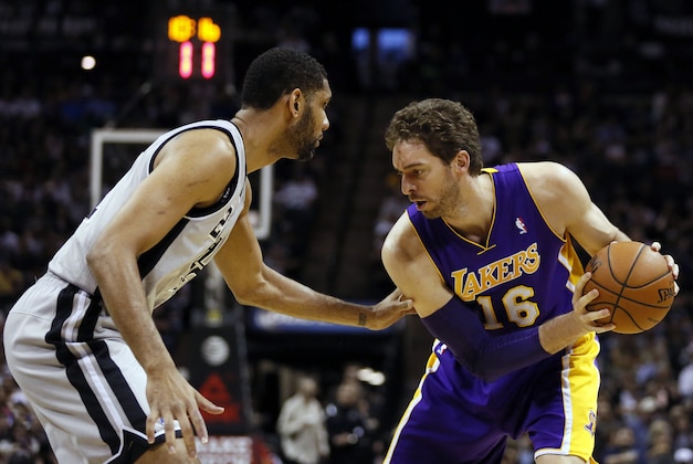 Mar 14, 2014; San Antonio, TX, USA; Los Angeles Lakers center Pau Gasol (16) is defended by San Antonio Spurs forward Tim Duncan (left) during the first half at AT&T Center. Mandatory Credit: Soobum Im-USA TODAY Sports