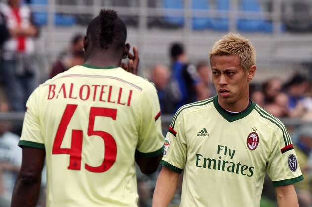 AC Milan's Keisuke Honda, right, of Japan, looks at his teammate Mario Balotelli prior to the start of a Serie A soccer match between Atalanta and AC Milan, in Bergamo, Italy, Sunday, May 11, 2014. (AP Photo/Felice Calabro')