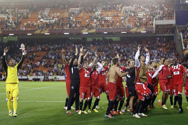 Sevilla team celebrates at the end of their Europa League semifinal second leg soccer match against Valencia at the Mestalla stadium in Valencia, Spain, Thursday, May 1, 2014. Valencia lost 2-0 in the first leg at Sevilla. The game ended 3-1. Sevilla qualified for the final Europa League. (AP Photo/Alberto Saiz)