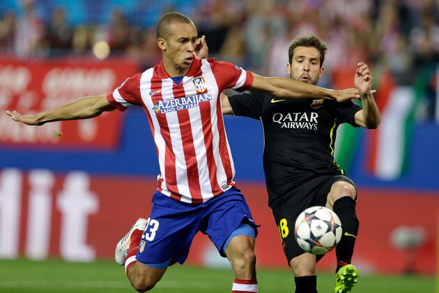 Barcelona's Jordi Alba, right, fights for the ball with Atletico's Miranda during the Champions League quarterfinal second leg soccer match between Atletico Madrid and FC Barcelona in the Vicente Calderon stadium in Madrid, Spain, Wednesday, April 9, 2014. (AP Photo/Paul White)