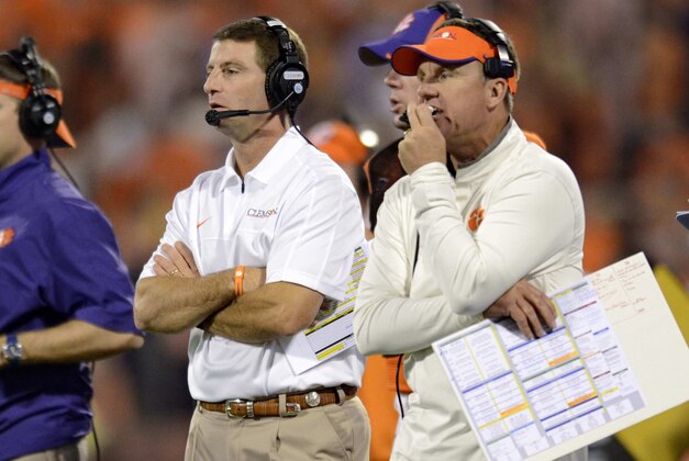 Clemson head coach Dabo Swinney, center, along with defensive coordinator Chad Morris, right, watch the action during the second half of an NCAA college football game against Maryland Saturday, Nov. 10, 2012 at Memorial Stadium in Clemson, S.C. Clemson won 45-10. (AP Photo/Richard Shiro)