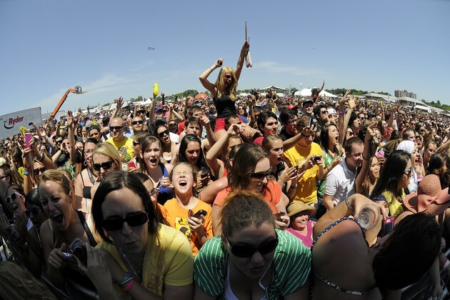 In this image taken with a fisheye lens, fans react as they watch Wiz Khalifa perform in the infield before the 137th Preakness Stakes horse race at Pimlico Race Course, Saturday, May 19, 2012, in Baltimore. (AP Photo/Nick Wass)