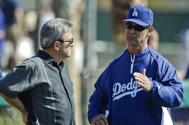 Los Angeles Dodgers manager Don Mattingly talks to general manager Ned Colletti during a spring training baseball workout Wednesday, Feb. 23, 2011, in Glendale, Ariz. (AP Photo/Morry Gash)