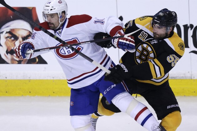 Boston Bruins defenseman Johnny Boychuk (55) tangles with Montreal Canadiens center Tomas Plekanec (14) during the second period of Game 5 in the second-round of the Stanley Cup hockey playoff series in Boston, Saturday, May 10, 2014. (AP Photo/Charles Krupa)