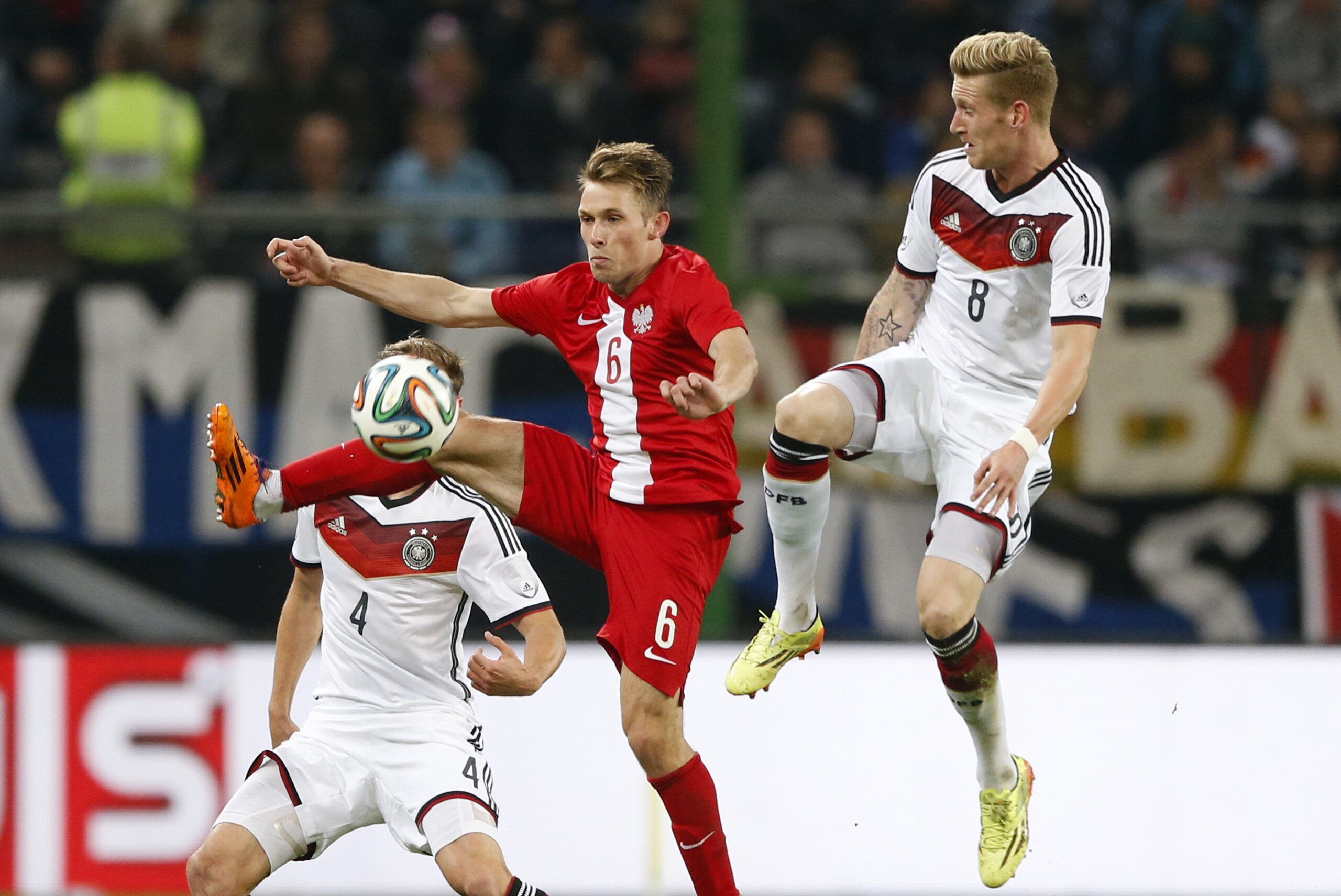 Germany's Andre Hahn, right, teammate Germany's Benedikt Hoewedes, background left, and Poland's Maciej Rybus challenge for the ball during a friendly soccer match between Germany and Poland in Hamburg, Germany, Tuesday, May 13, 2014.  (AP Photo/Matthias Schrader)