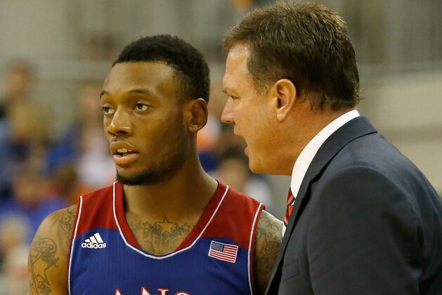 GAINESVILLE, FL - DECEMBER 10:  Head coach Bill Self of the Kansas Jayhawks speaks with Naadir Tharpe #10 during the game against the Florida Gators at Stephen C. O'Connell Center on December 10, 2013 in Gainesville, Florida.  (Photo by Sam Greenwood/Getty Images)
