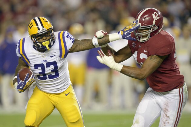 Nov 9, 2013; Tuscaloosa, AL, USA; LSU Tigers running back Jeremy Hill (33) carries the ball and stiff arms Alabama Crimson Tide linebacker Adrian Hubbard (42) in the second quarter at Bryant-Denny Stadium. Mandatory Credit: John David Mercer-USA TODAY Sports