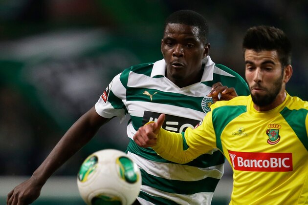 Sporting's William Carvalho, left, fights for the ball with Pacos de Ferreira's Sergio Oliveira  during their Portuguese league soccer match Sunday, Dec. 1, 2013, at Sporting's Alvalade stadium in Lisbon. (AP Photo/Armando Franca)