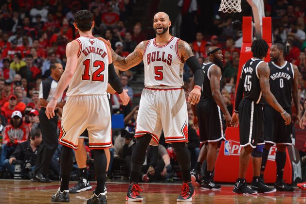 CHICAGO, IL - APRIL 27: Carlos Boozer #5 celebrates with teammate Kirk Hinrich #12 of the Chicago Bulls during a timeout in Game Four of the Eastern Conference Quarterfinals against the Brooklyn Nets as part of the 2013 NBA Playoffs on April 27, 2013 at United Center in Chicago, Illinois. NOTE TO USER: User expressly acknowledges and agrees that, by downloading and or using this photograph, User is consenting to the terms and conditions of the Getty Images License Agreement. Mandatory Copyright Notice: Copyright 2013 NBAE (Photo by Jesse D. Garrabrant/NBAE via Getty Images)