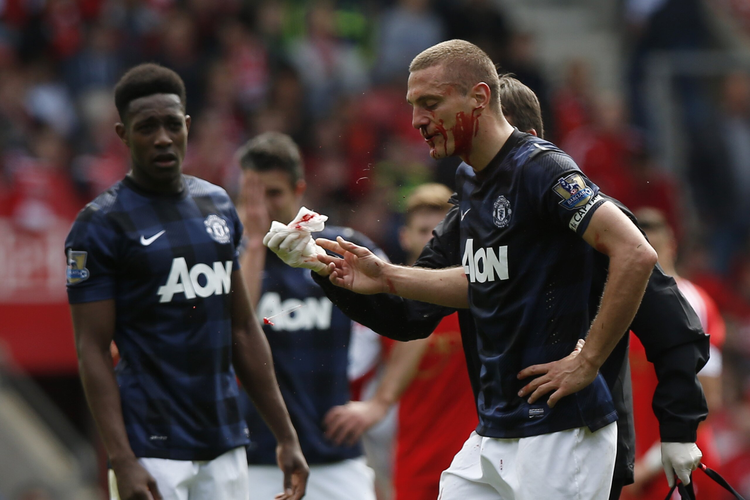 Manchester United's Nemanja Vidic, right, leaves the pitch after a nose bleed during their English Premier League soccer match against Southampton at St Mary's stadium, Southampton, England, Sunday, May 11, 2014. (AP Photo/Sang Tan)