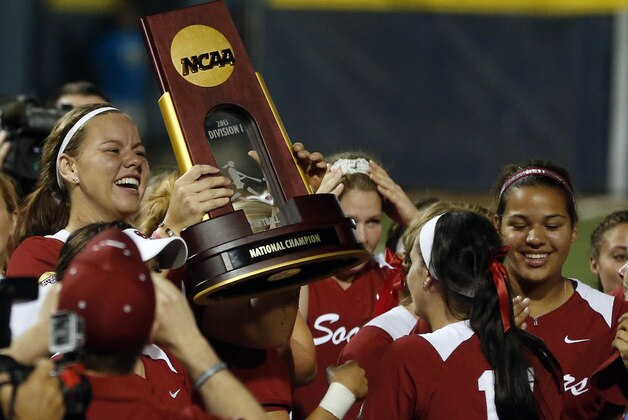 Oklahoma's Keilani Ricketts, left, holds the championship trophy after Oklahoma defeated Tennessee in the second game of the best of three Women's College World Series NCAA softball championship series in Oklahoma City, Tuesday, June 4, 2013. Oklahoma won the game 4-0 and the best of three series in two games.(AP Photo/Sue Ogrocki)