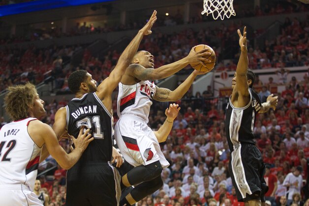 May 12, 2014; Portland, OR, USA; Portland Trail Blazers guard Damian Lillard (0) shoots between San Antonio Spurs forward Tim Duncan (21) and Spurs forward Kawhi Leonard (2) in the first half of game four of the second round of the 2014 NBA Playoffs at the Moda Center. Mandatory Credit: Jaime Valdez-USA TODAY Sports