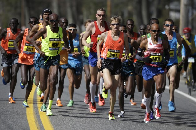 Ryan Hall, of Redding, Calif., center, runs near Meb Keflezighi, of San Diego, Calif., front right, along the route of the 118th Boston Marathon, Monday, April 21, 2014. (AP Photo/Steven Senne)