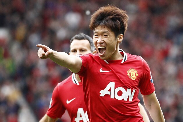 Manchester United's Ji-Sung Park celebrates with team mate Ryan Giggs after scoring a goal against Arsenal during their English Premier League soccer match at Old Trafford, Manchester, England, Sunday Aug. 28, 2011. (AP Photo/Jon Super)
