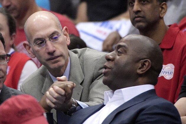 NBA Commissioner Adam Silver, left, shakes hands with Magic Johnson as they watch the Los Angeles Clippers play the Oklahoma City Thunder in the first half of Game 4 of the Western Conference semifinal NBA basketball playoff series, Sunday, May 11, 2014, in Los Angeles. (AP Photo/Mark J. Terrill)