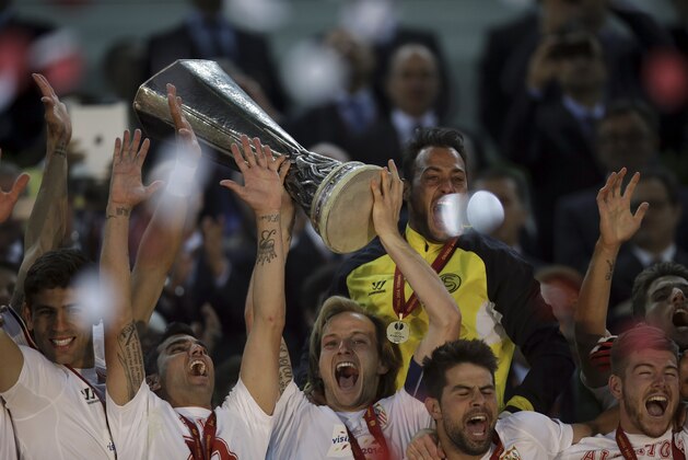 Sevilla's Ivan Rakitic holds up the trophy after winningthe Europa League soccer final between Sevilla and Benfica, at the Turin Juventus stadium in Turin, Italy, Wednesday, May 14, 2014. (AP Photo/Andrew Medichini)