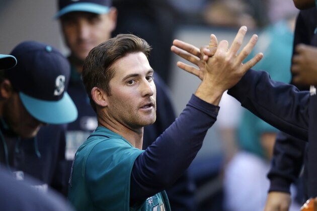 Seattle Mariners' Brad Miller is congratulated in the dugout after scoring against the Tampa Bay Rays in the second inning of a baseball game Monday, May 12, 2014, in Seattle. (AP Photo)