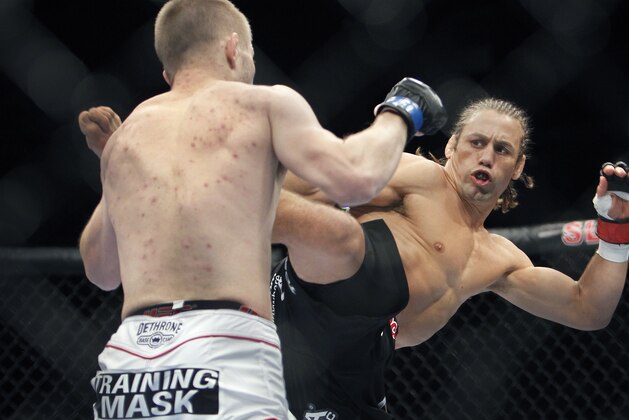 Urijah Faber, right, battles Michael McDonald in a UFC Mixed Martial Arts bantamweight fight in Sacramento, Calif., on Saturday, Dec. 14, 2013.(AP Photo/Steve Yeater)