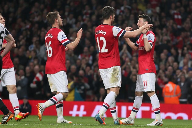 Arsenal's Mesut Ozil, right celebrates after scoring his sides second goal during their English Premier League soccer match between Arsenal and Newcastle United at the Emirates stadium in London, Monday, April 28,  2014. (AP Photo/Alastair Grant)