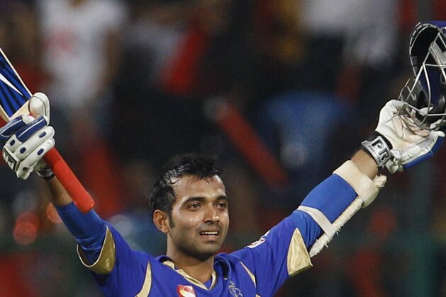 Rajasthan Royals batsman Ajinkya Rahane raises his bat and helmet to celebrate scoring a century during their Indian Premier League (IPL) cricket match against Royal Challengers Bangalore in Bangalore, India, Sunday, April 15, 2012. (AP Photo/Aijaz Rahi)