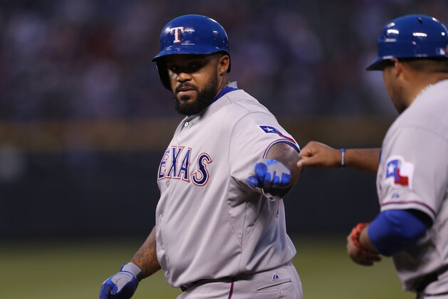 Texas Rangers' Prince Fielder, left, is congratulated after hitting a single by first base coach Benjie Molina against the Colorado Rockies in the fourth inning of a baseball game in Denver on Monday, May 5, 2014. (AP Photo/David Zalubowski)