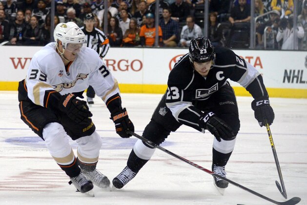 May 14, 2014; Los Angeles, CA, USA; Anaheim Ducks right wing Jakob Silfverberg (33) and Los Angeles Kings right wing Dustin Brown (23) reach for the puck in game six of the second round of the 2014 Stanley Cup Playoffs at Staples Center. The Kings defeated the Ducks 2-1 to tie the series 3-3. Mandatory Credit: Kirby Lee-USA TODAY Sports