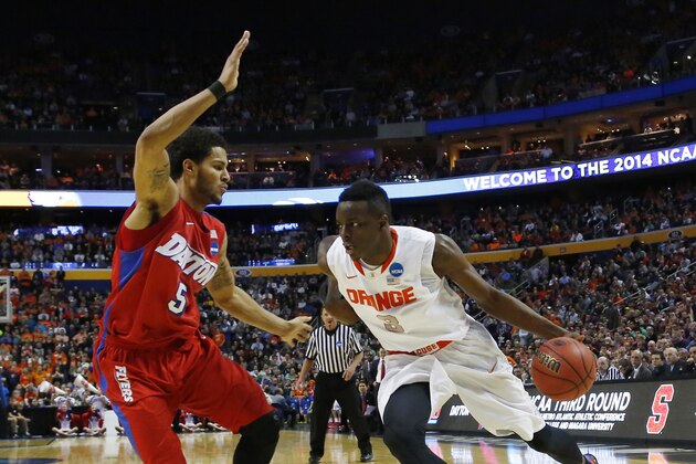Syracuse forward Jerami Grant (3) drives  against Dayton forward Devin Oliver (5) in the NCAA men's college basketball tournament in Buffalo, N.Y., Saturday, March 22, 2014. Dayton won the game 55-53. (AP Photo/Bill Wippert)