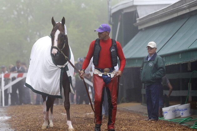 Exercise rider Willie Delgado, center, leads Kentucky Derby winner California Chrome to his stable as trainer Art Sherman, right, watches after a workout at Pimlico Race Course in Baltimore, Thursday, May 15, 2014. The Preakness Stakes horse race is scheduled to take place May 17. (AP Photo/Patrick Semansky)