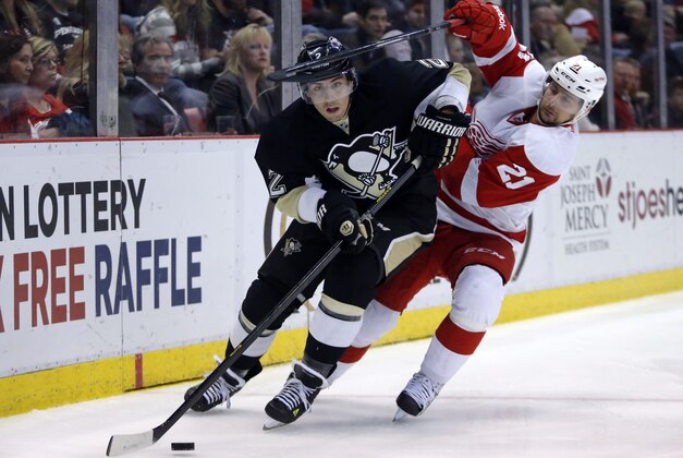 Detroit Red Wings' Tomas Tatar (21), of Slovakia, tries to get to the puck controlled by Pittsburgh Penguins' Matt Niskanen (2) during the second period of an NHL hockey game Thursday, March 20, 2014 in Detroit. The Red Wings defeated the Penguins 5-4 in overtime. (AP Photo/Duane Burleson)