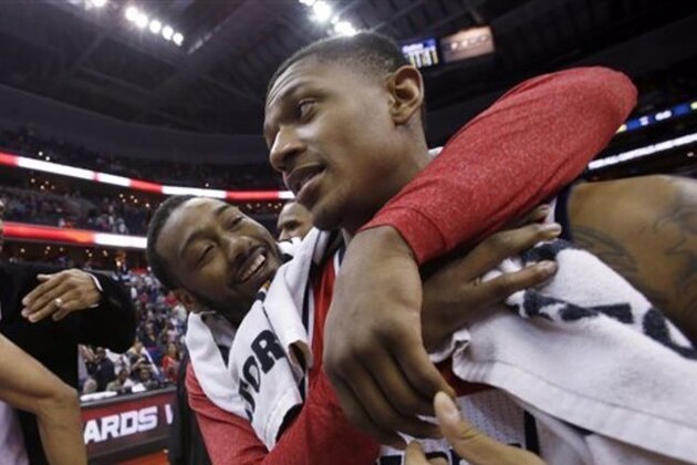 Washington Wizards guards John Wall, left, and Bradley Beal celebrate after an NBA basketball game against the Boston Celtics on Wednesday, April 2, 2014, in Washington. The Wizards won 118-92, and clinched a playoff berth. (AP Photo/Alex Brandon)
