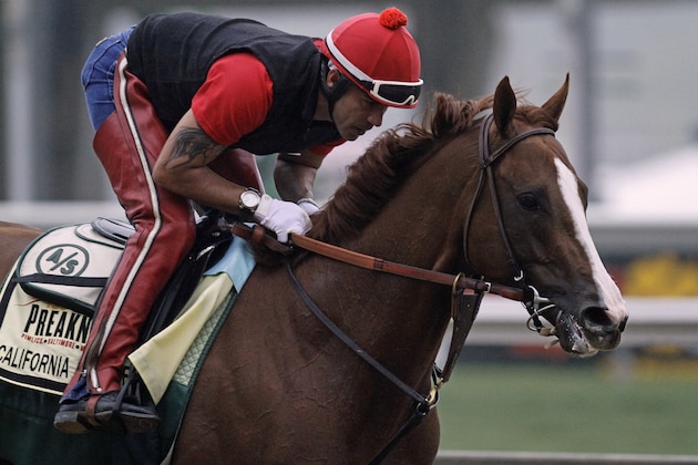 Exercise rider Willie Delgado gallops Kentucky Derby winner California Chrome at Pimlico Race Course in Baltimore, Md., Wednesday, May 14, 2014. The Preakness Stakes horse race is scheduled for May 17 at Pimlico. (AP Photo/Garry Jones)