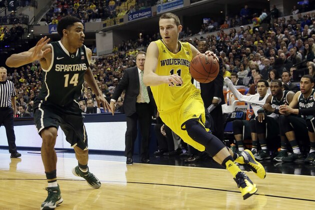 Michigan guard Nik Stauskas (11) drives against Michigan State guard Gary Harris (14) in the first half of an NCAA college basketball game in the championship of the Big Ten Conference tournament Sunday, March 16, 2014, in Indianapolis. (AP Photo/AJ Mast)