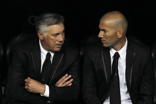 Real Madrid's coach Carlo Ancelotti, left, from Italy and coach assistant Zindine Zidane gesture during a Spanish La Liga soccer match against Betis at the Santiago Bernabeu stadium in Madrid, Spain, Sunday, Aug. 18, 2013. (AP Photo/Andres Kudacki)