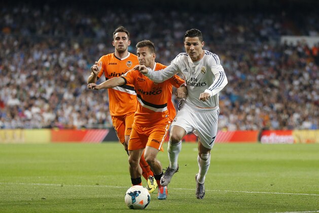 Real Madrid's Cristiano Ronaldo from Portugal, right, duels for the ball with Valencia's Joao Pereira from Portugal during a Spanish La Liga soccer match at the Santiago Bernabeu stadium  in Madrid, Spain, Sunday, May 4, 2014 . (AP Photo/Daniel Ochoa de Olza)