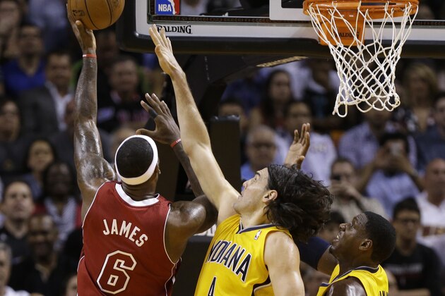 Miami Heat's LeBron James (6) shoots as Indiana Pacers' Luis Scola (4) and Ian Mahinmi (28) defend in the first half of an NBA basketball game, Wednesday, Dec. 18, 2013, in Miami. (AP Photo/Lynne Sladky)