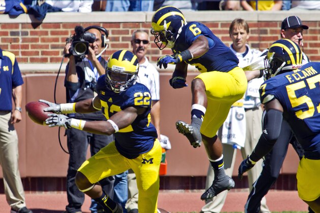 Michigan safety Jarrod Wilson (22) celebrates with defensive back Raymon Taylor (6) after intercepting an Akron pass in the end zone in the fourth quarter of an NCAA college football game in Ann Arbor, Mich., Saturday, Sept. 14, 2013. Michigan won 28-24. (AP Photo/Tony Ding)