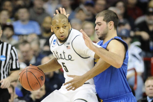 Mar 20, 2014; Spokane, WA, USA; Michigan State Spartans forward Adreian Payne (5) dribbles against Delaware Fightin Blue Hens forward Carl Baptiste (33) in the first half of a men's college basketball game during the second round of the 2014 NCAA Tournament at Veterans Memorial Arena. Mandatory Credit: James Snook-USA TODAY Sports