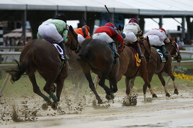 Horses race down a sloppy track during the second race before the Black-Eyed Susan Stakes horse race at Pimlico Race Course, Friday, May 16, 2014, in Baltimore. The 139th Preakness horse race takes place Saturday. (AP Photo/Matt Slocum)