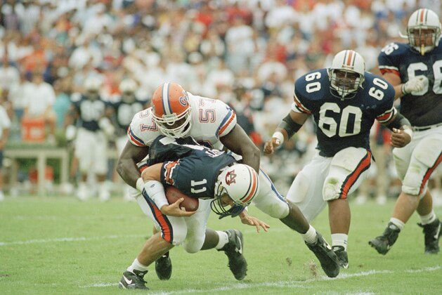 Auburn quarterback Stan White picks up a first down despite Florida end Kevin Carter (57) on his back in second quarter in their SEC game at Auburn, Ala., Oct. 16, 1993. (AP Photo/Jay Sailors)