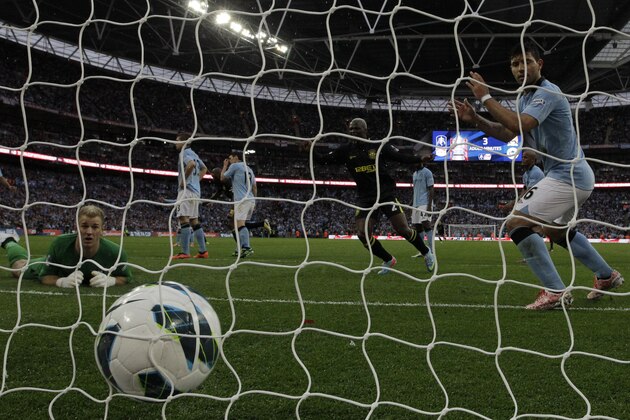 Manchester City's goalkeeper Joe Hart, left, and Sergio Aguero, right, watch the ball after Wigan Athletic's Ben Watson goal during their English FA Cup final soccer match at Wembley Stadium, London, Saturday, May 11, 2013. (AP Photo/Matt Dunham)