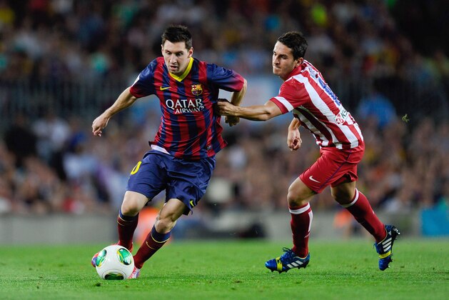 BARCELONA, SPAIN - AUGUST 28:  Lionel Messi of FC Barcelona duels for the ball with Koke Resurreccion of Atletico de Madrid during the Spanish Super Cup second leg match between FC Barcelona and Atletico de Madrid at Nou Camp on August 28, 2013 in Barcelona, Spain.  (Photo by David Ramos/Getty Images)