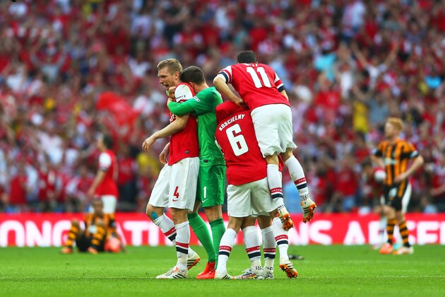 LONDON, ENGLAND - MAY 17:  Despair for Hull City  as Per Mertesacker (4), Wojciech Szczesny (1), Laurent Koscielny (6) and Mesut Oezil of Arsenal (11) celebrate victory after the FA Cup with Budweiser Final match between Arsenal and Hull City at Wembley Stadium on May 17, 2014 in London, England.  (Photo by Paul Gilham/Getty Images)