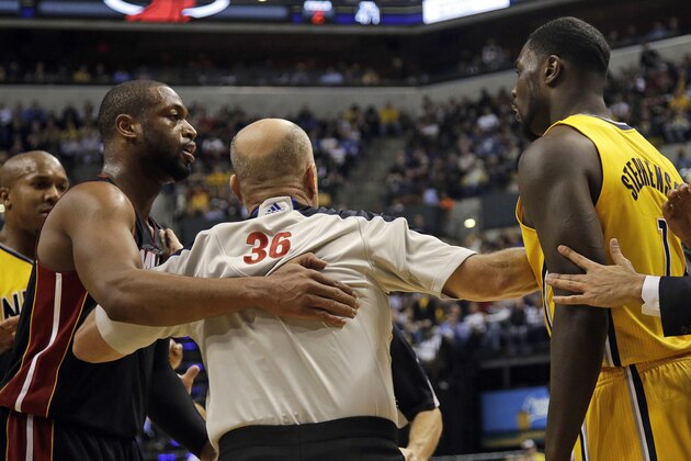 In this Wednesday, March 26, 2014 photo, Miami Heat guard Dwyane Wade, left, and Indiana Pacers guard Lance Stephenson, right, are separated by official David Jones during the second half of an NBA basketball game in Indianapolis. The Pacers won 84-83. Before the game, the teams chided one another with dueling comments. Afterward, nobody was ready to make up. And in between, the action got downright nasty. (AP Photo/AJ Mast)