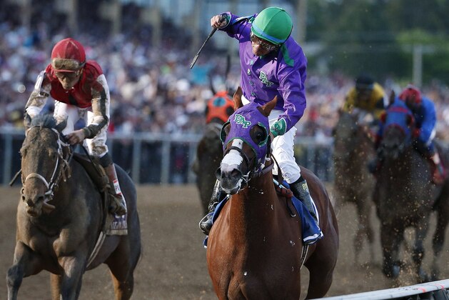 Jockey Victor Espinoza, center, aboard California Chrome, celebrates after winning the 139th Preakness Stakes horse race at Pimlico Race Course, Saturday, May 17, 2014, in Baltimore. Ride On Curlin, left, ridden by Joel Rosario, finished second. (AP Photo/Matt Slocum)