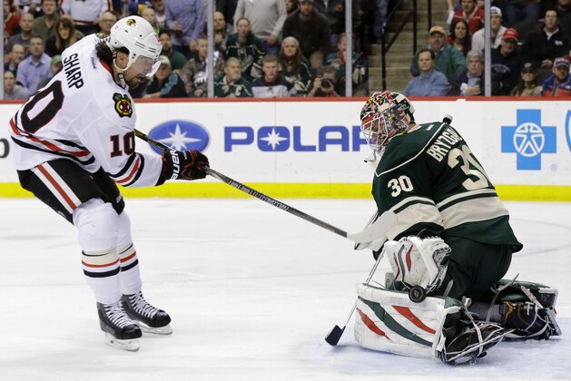 Minnesota Wild goalie Ilya Bryzgalov (30), of Russia, deflects a point-blank shot by Chicago Blackhawks left wing Patrick Sharp (10) during the second period of Game 6 of an NHL hockey second-round playoff series, in St. Paul, Minn., Tuesday, May 13, 2014. (AP Photo/Ann Heisenfelt)